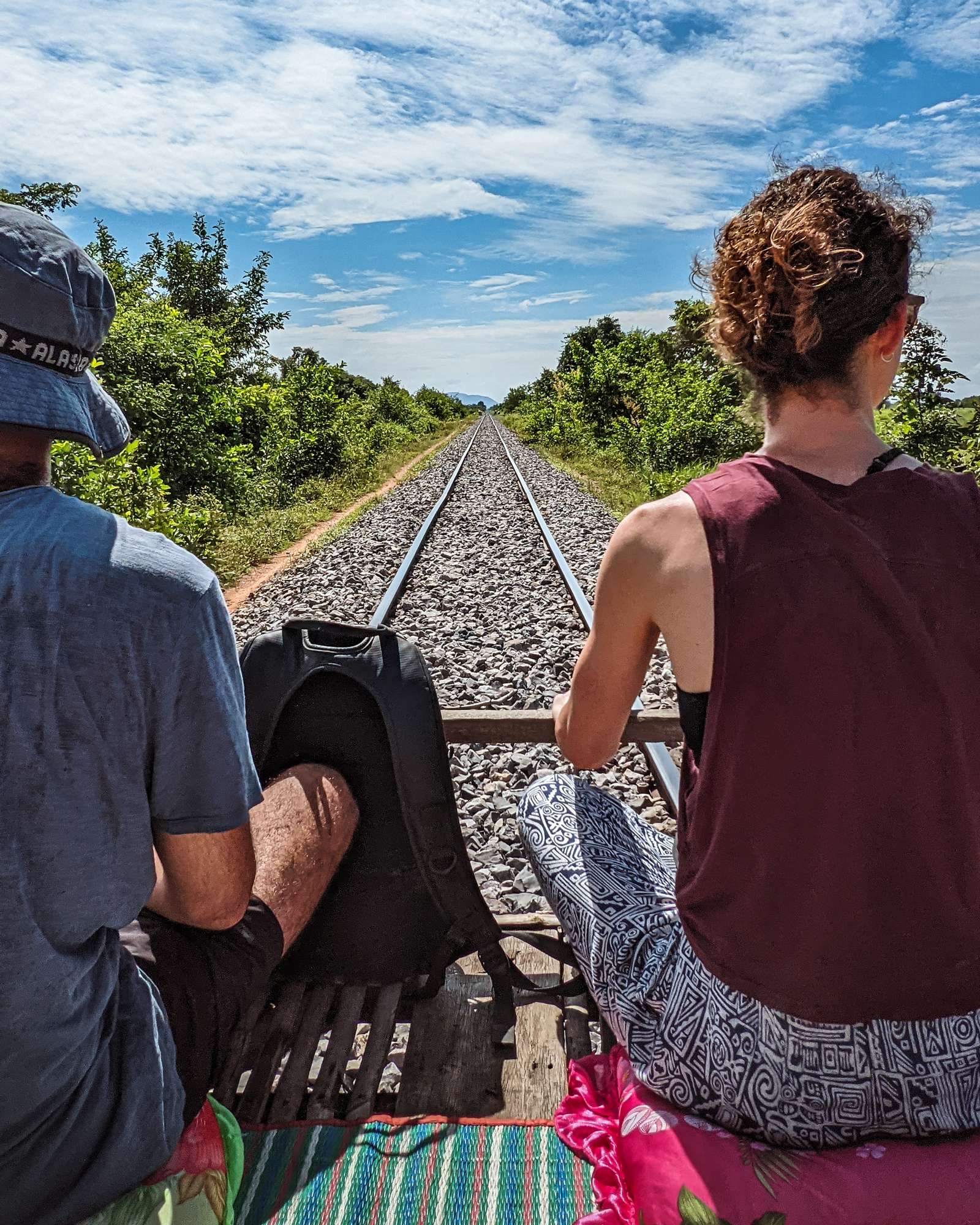Two people riding the Battambang bamboo train