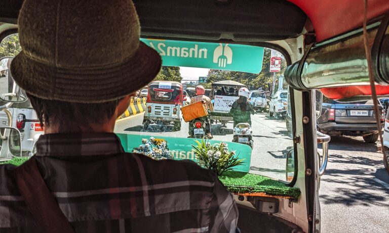Back of a tuk tuk driver driving through Phnom Penh