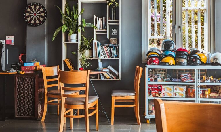 Mooka's Home lobby with chairs, a bookshelf, books, plants, and motorcycle helmets