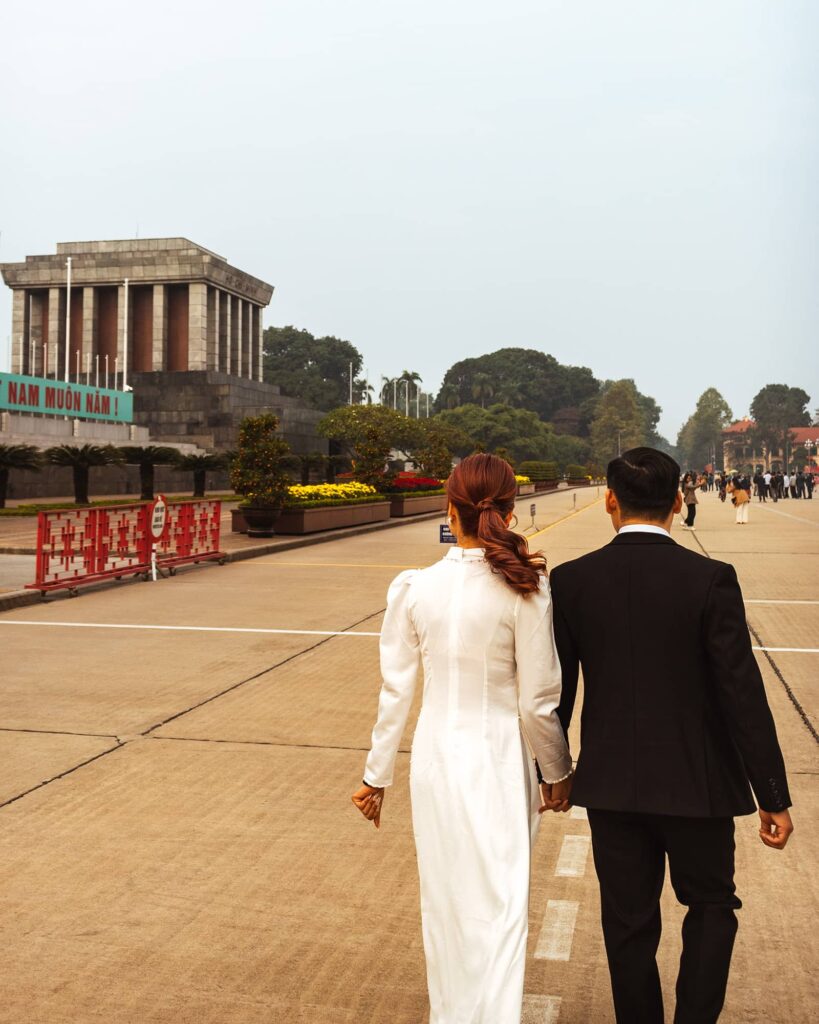 Couple holding hands and walking toward Ho Chi Minh's Mausoleum