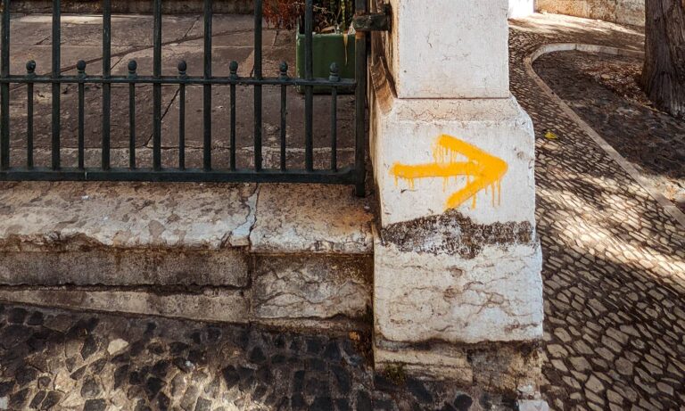 Yellow Camino de Santiago arrow at the front of the Church of Saint James in Lisbon