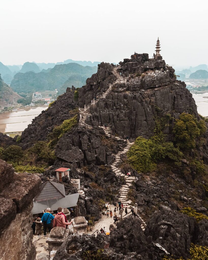 Stone stairs on a mountain that lead to a pagoda at Hang Mua