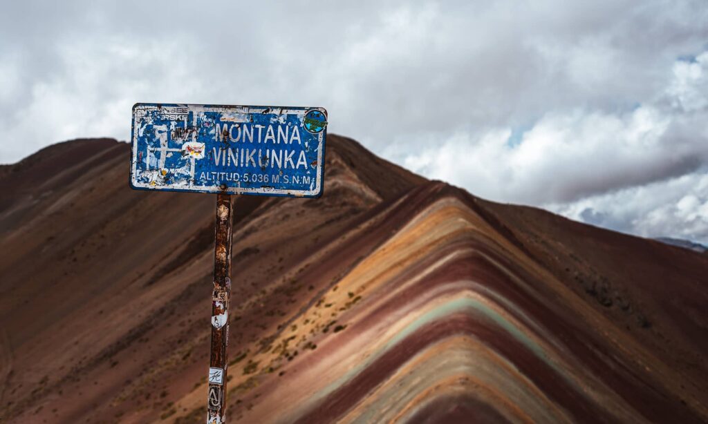 Montana Vinikunka sign with the Rainbow Mountain in the background